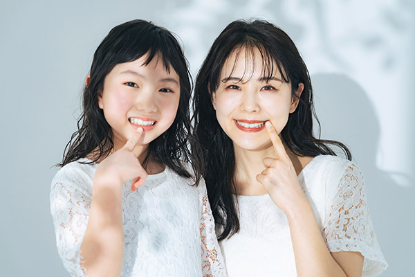 歯を見せて笑う親子